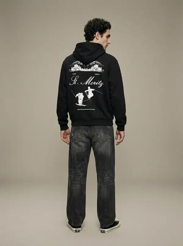black st. moritz embroidered hoodie worn by an AI male model, studio shoot